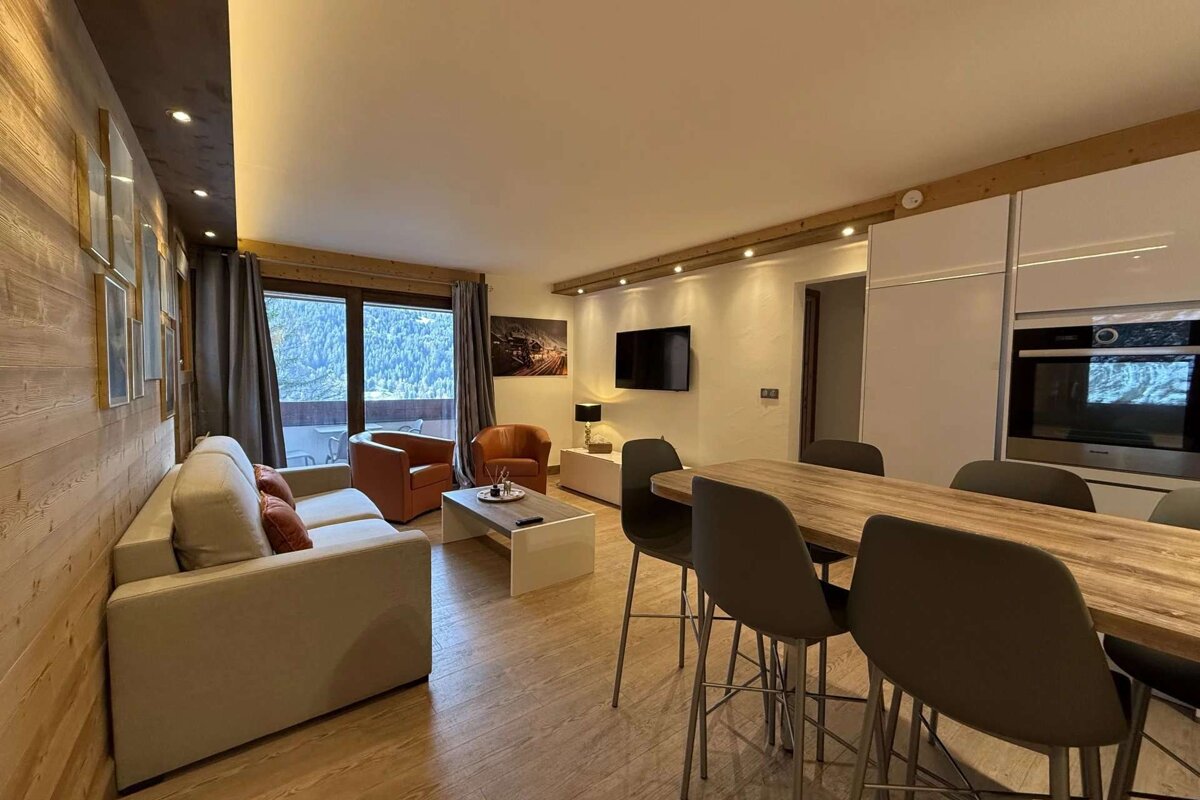 A living room with a couch a table and chairs