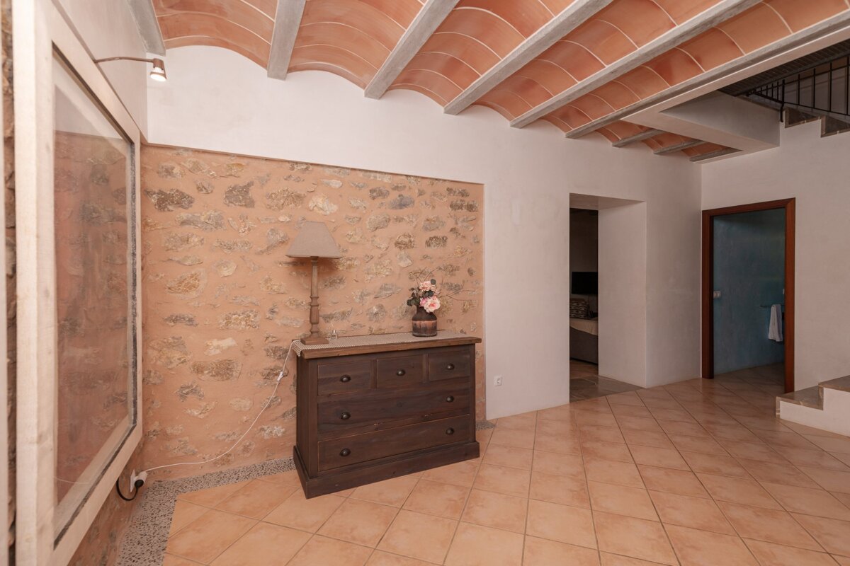 A room with a dresser and a lamp on it