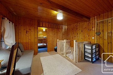 A room with a couch and a shelf with the word alpine on it