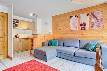 A living room with a couch and paintings on the wall
