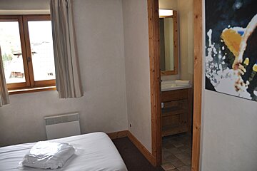 A bedroom with a sink and a picture on the wall