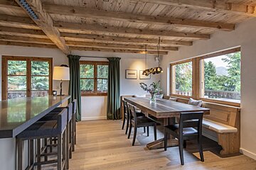 A dining room with a wooden table and chairs