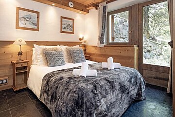 A bedroom with a large bed and a window