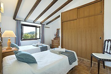 A bedroom with two twin beds and a dresser