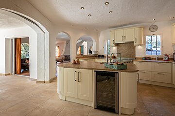 A kitchen with white cabinets and a clock on the wall