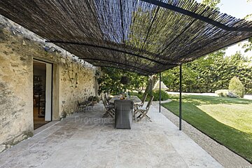 A patio with a table and chairs under a canopy that says provence