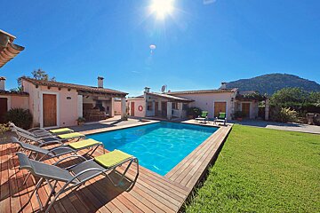 A house with a large swimming pool in front of it