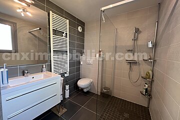 A bathroom with a toilet and a sink with the website cnxim visible