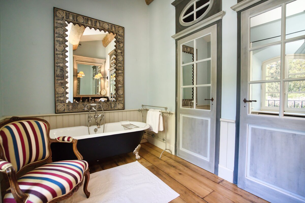 A bathroom with a striped chair and a bathtub