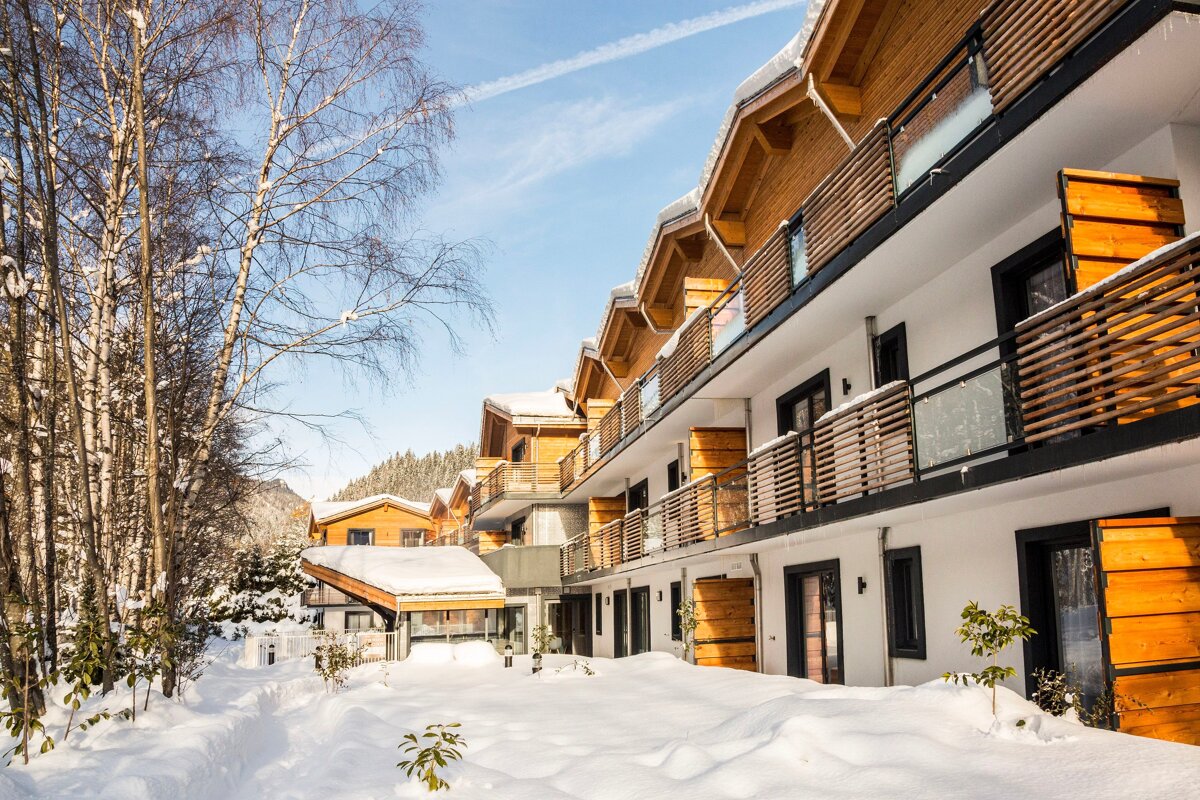 A snowy building with a lot of windows and balconies