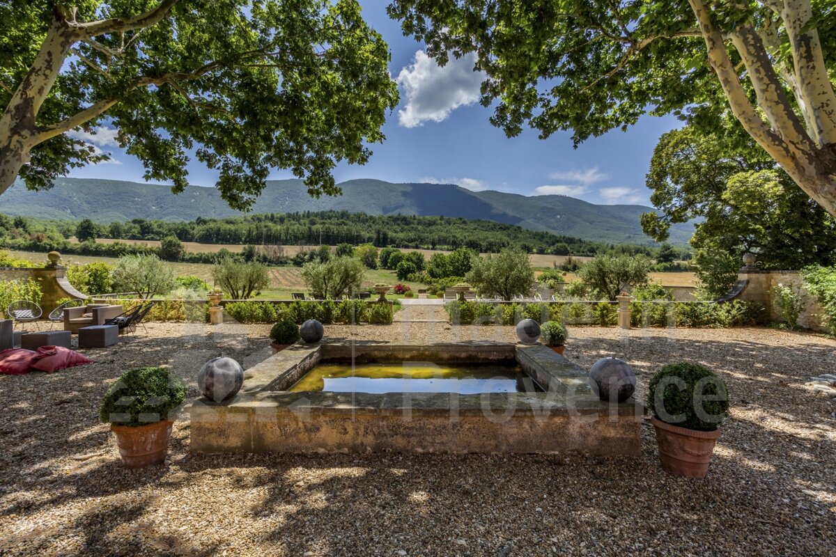 A picture of a fountain with mountains in the background