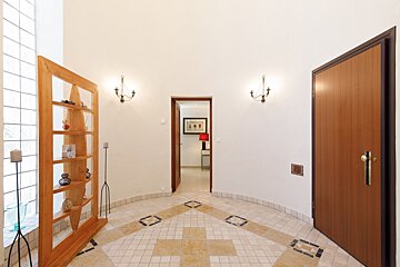 A hallway with a tiled floor and a wooden door