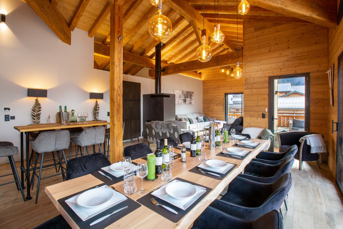 A dining room table with a bottle of wine on it