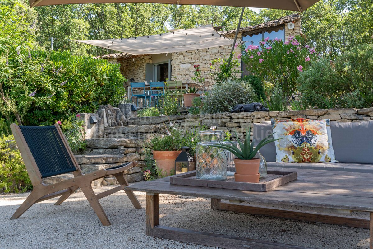 A patio with a couch and chairs under an umbrella