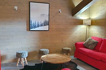 A living room with a red couch and a picture on the wall