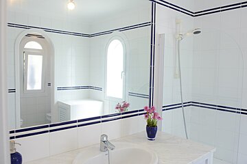 A bathroom with blue and white tiles and a sink