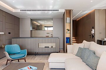 A living room with a white couch and a blue chair