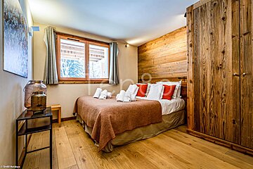 A bedroom with a large bed and a wooden wall