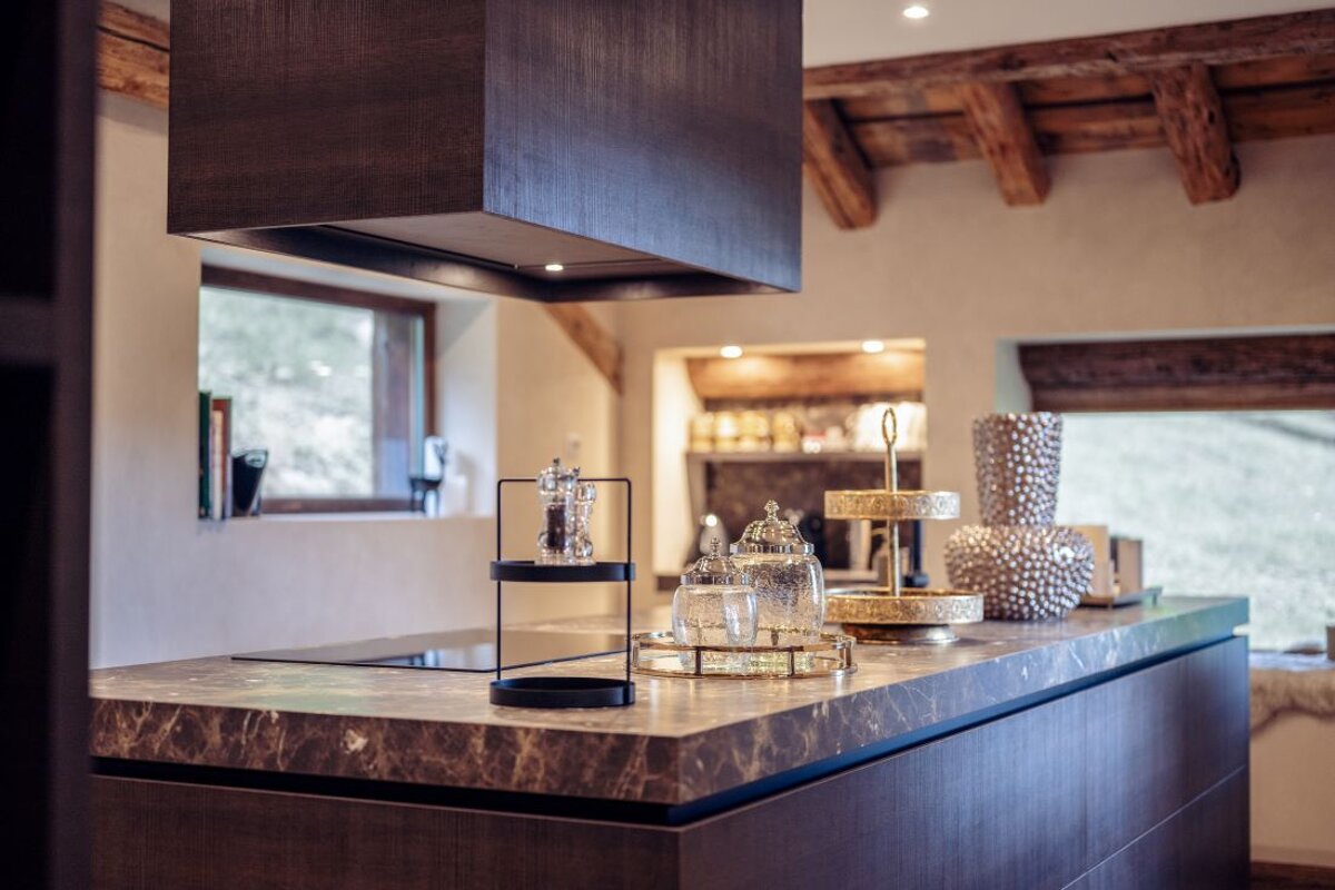 A kitchen with a marble counter top and a hood