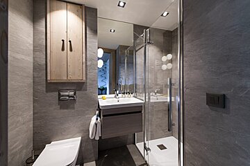 A bathroom with a toilet a sink and a shower