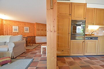 A kitchen with wooden cabinets and a stainless steel oven