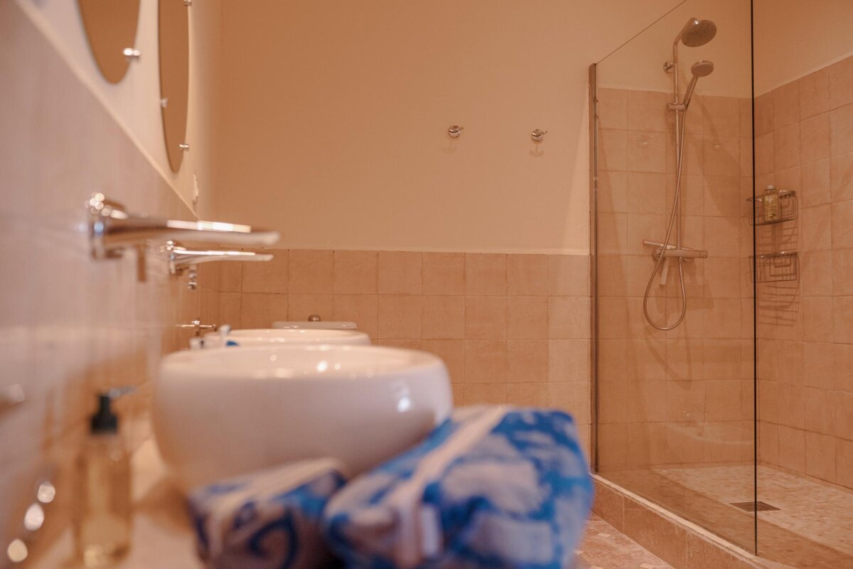 A bathroom with two sinks and a walk in shower