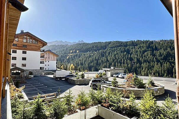 A view of a parking lot with mountains in the background