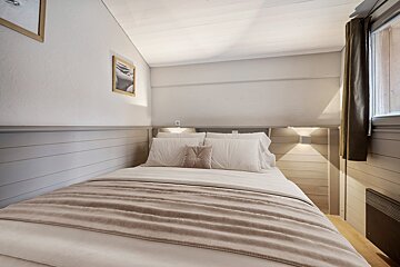 A bedroom with a bed and a picture on the wall