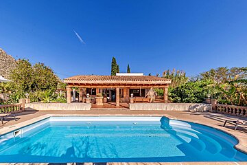A house with a large swimming pool in front of it