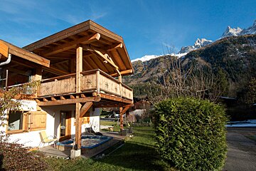 A house with a hot tub and mountains in the background