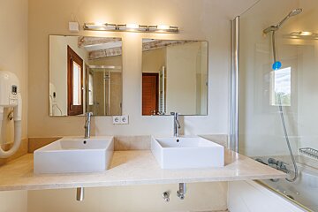 A bathroom with two sinks and a shower