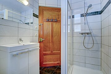 A bathroom with a sink and a walk in shower