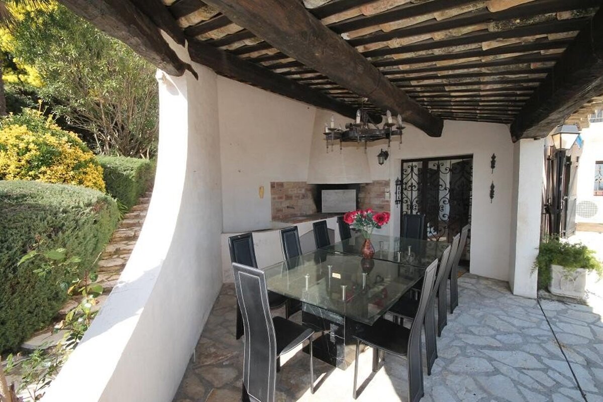 A table with a vase of red flowers on it