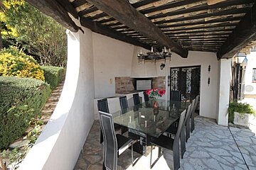 A table with a vase of red flowers on it
