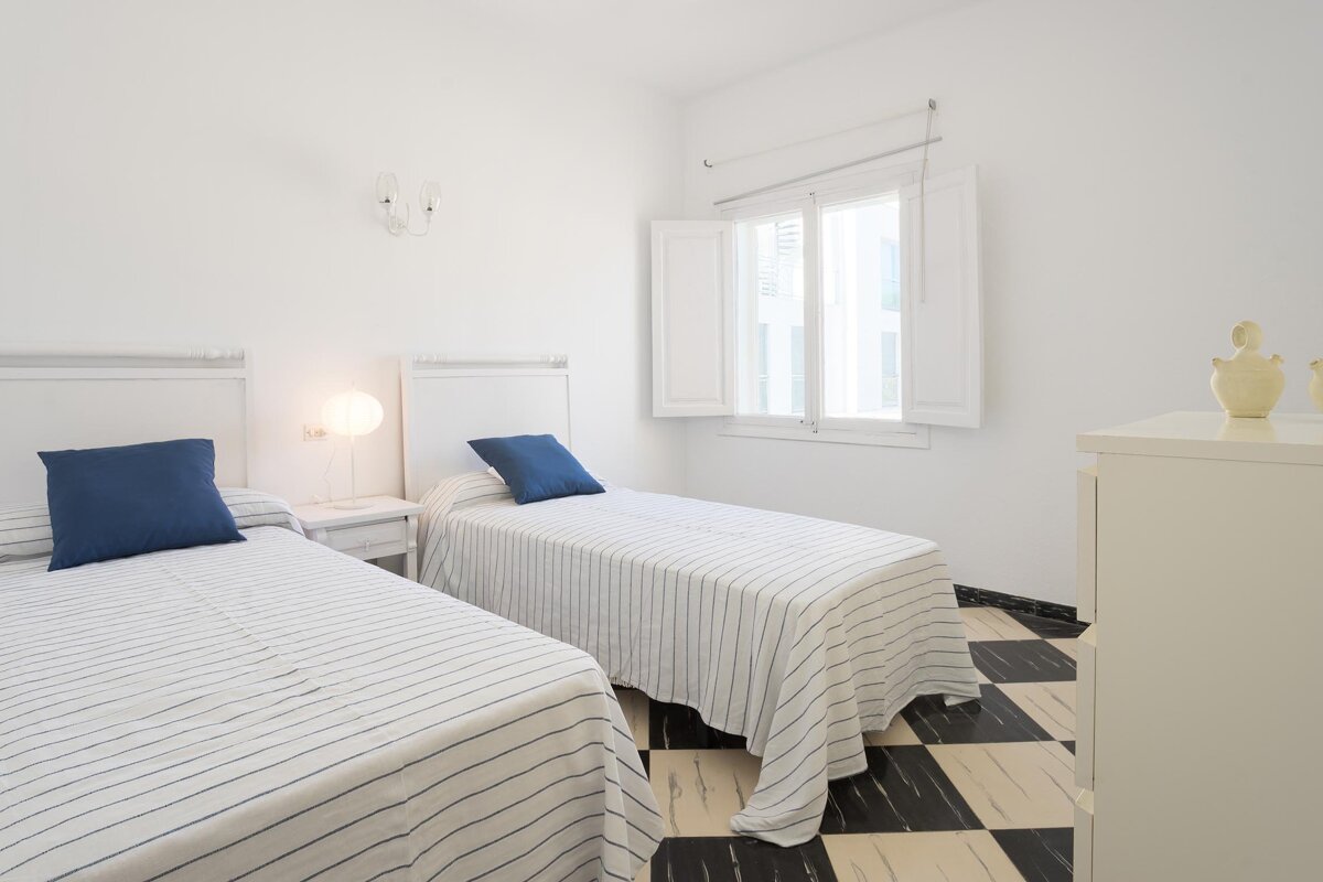 A bedroom with two twin beds and a window