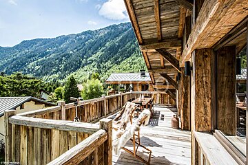 A wooden balcony with a view of the mountains