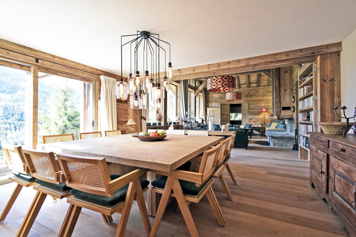 A dining room with a large wooden table and chairs