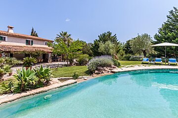 A large swimming pool with a house in the background
