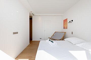 A bedroom with a chair and a painting on the wall