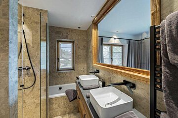 A bathroom with two sinks and a large mirror