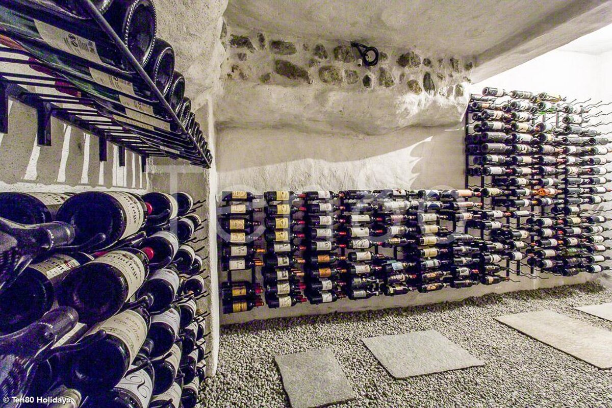 Bottles of wine are lined up in a wine cellar