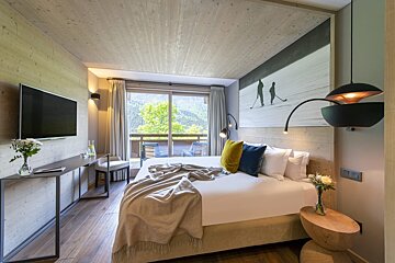 A hotel room with a large bed and a flat screen tv