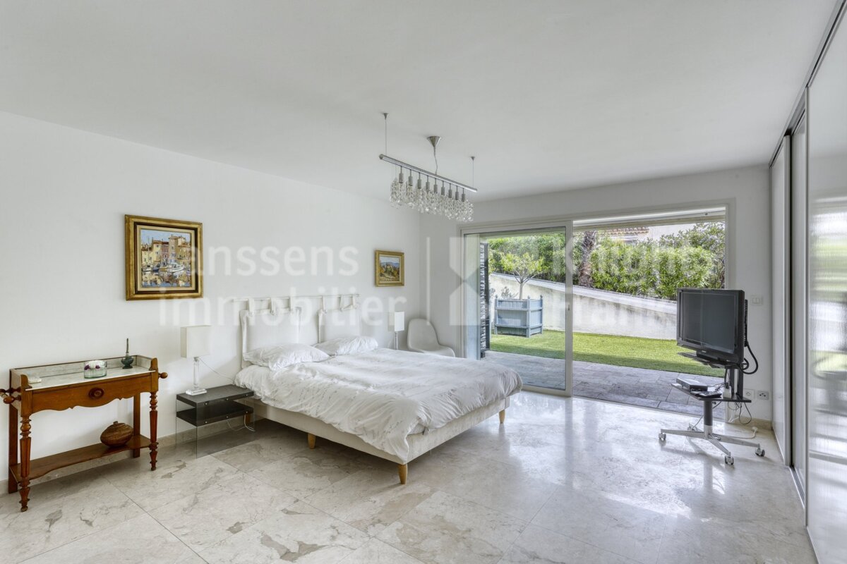 A bedroom with a large bed and a television and the word immobilier on the wall