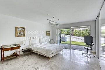 A bedroom with a large bed and a television and the word immobilier on the wall