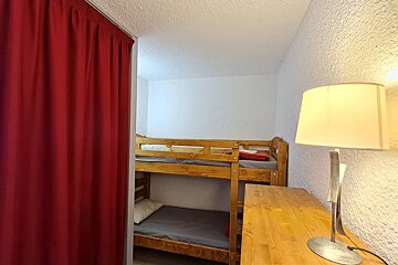 A bedroom with bunk beds and a lamp