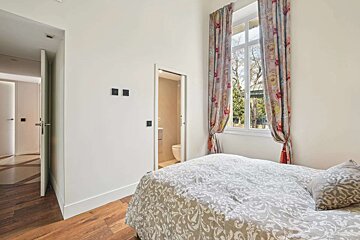 A bedroom with a bed and a window with floral curtains