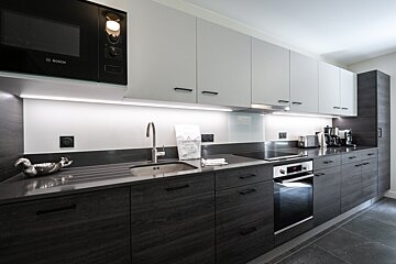 A kitchen with a bosch microwave above the sink