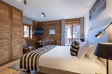 A bedroom with a large bed and a television