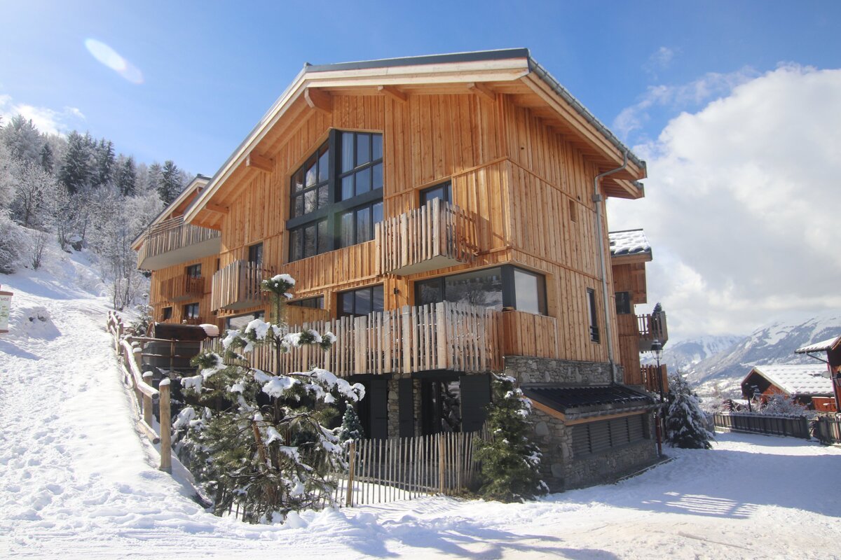 A large wooden house with a balcony in the snow