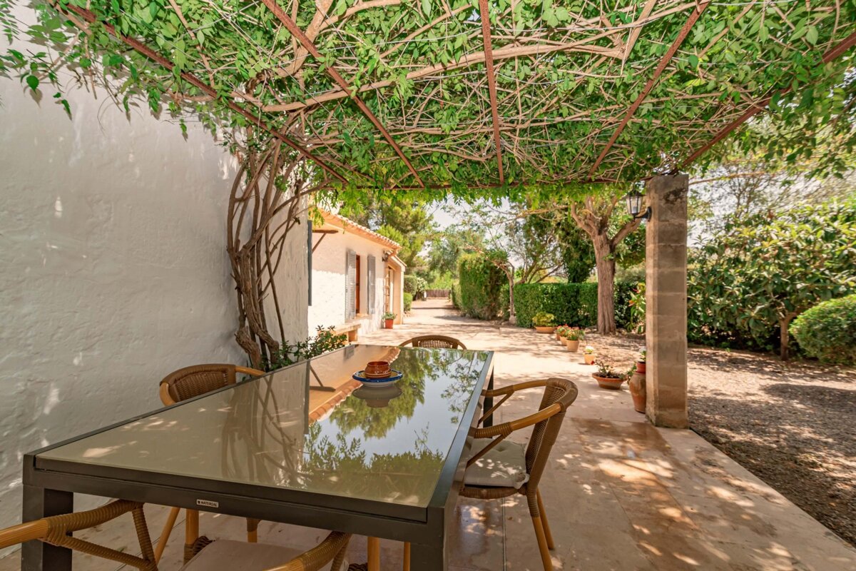 A patio with a table and chairs under a pergola
